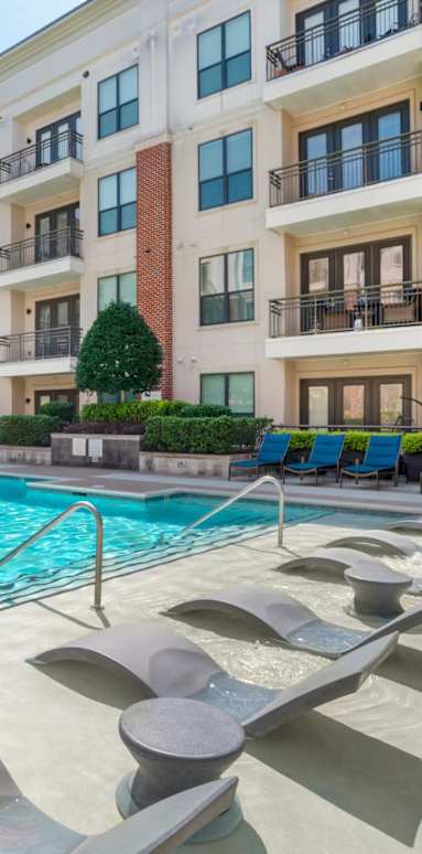A swimming pool in front of apartment buildings.
