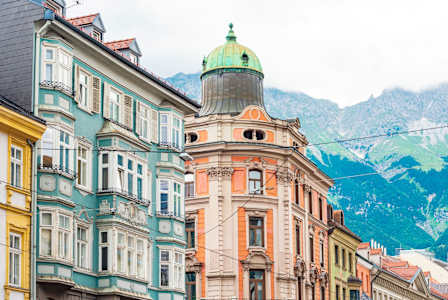 A street with buildings and a mountain in the background.