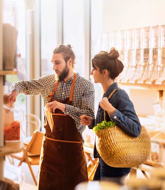 a man and a woman in a grocery store with a basket of food