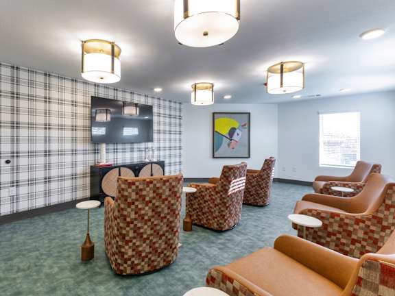 A room with a checkered wallpaper and a television on the wall.