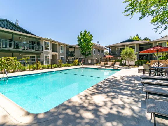 our apartments offer a swimming pool with our apartment buildings in the background at Pleasanton Glen Apartments, California