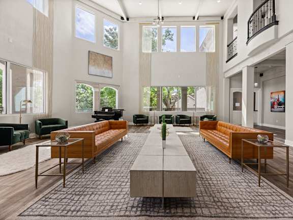A spacious living room with a long wooden table in the center and multiple seating options.