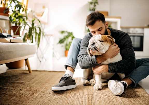 A man is sitting on the floor with his dog.