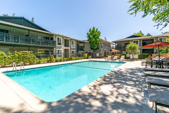 our apartments offer a swimming pool with our apartment buildings in the background at Pleasanton Glen Apartments, California
