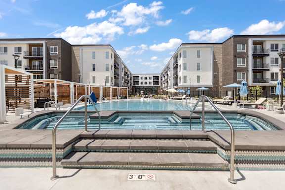 A row of modern apartment buildings are lined up on a grassy area.