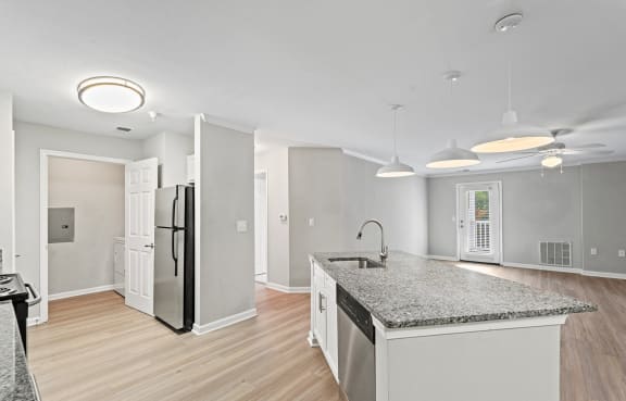 a kitchen with dark wood cabinets and stainless steel appliances at SomerHill Farms Apartments in VA 20155