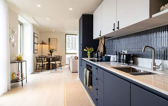 Open-plan kitchen and dining area in a one-bedroom apartment.