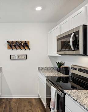 A kitchen with granite countertops and white cabinets at The Summit Townhomes in Oak Ridge, TN