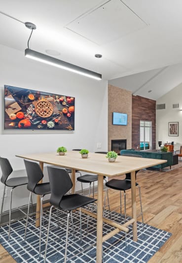a dining room with a glass table and white chairs at SomerHill Farms Apartments in Gainesville, Virginia