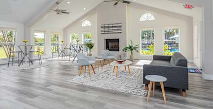 A spacious living room with a fireplace and a ceiling fan.