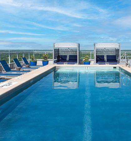 A large outdoor swimming pool with lounge chairs and a view of the horizon.