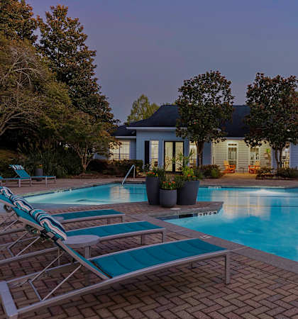 Resort style swimming pool with sundeck at dusk - Evergreen Lenox Park