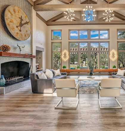 A living room with a fireplace and a large clock on the wall.