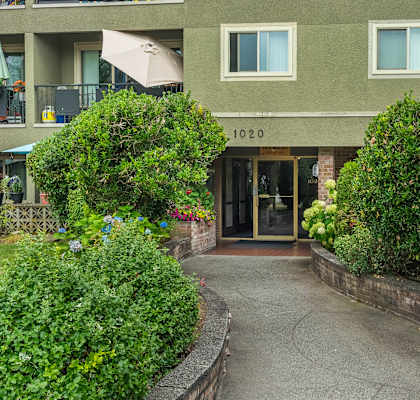The entrance to apartment 1020 is flanked by green shrubbery.
