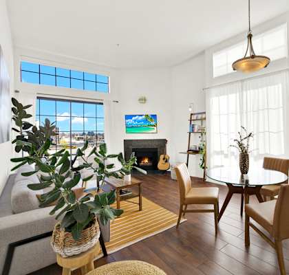 A living room with a fireplace and a TV on the wall at Beverly Wooster Apartments, Los Angeles, California
