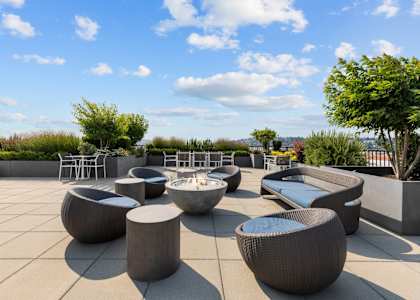 a roof terrace with tables and chairs and a pool