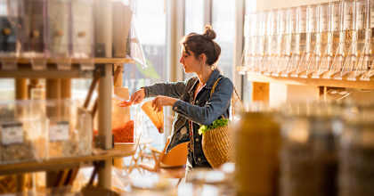 A woman is shopping in a store with a variety of items on display.