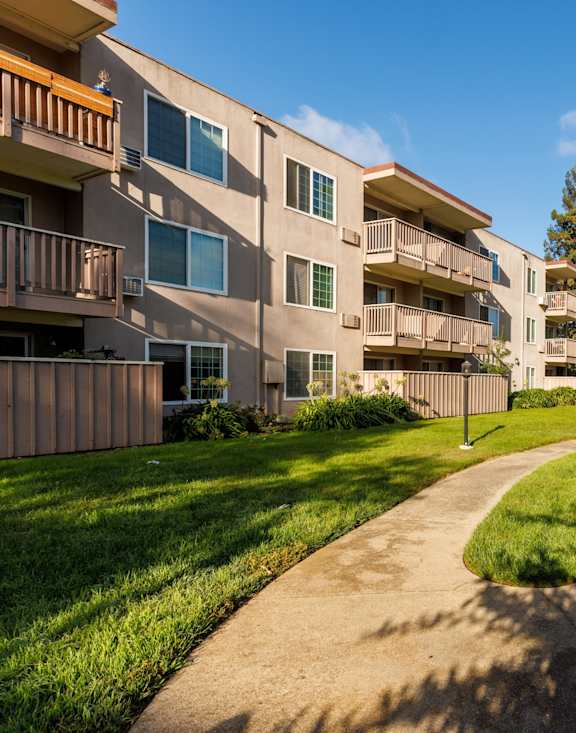 A sunny day at a residential area with apartments and greenery.