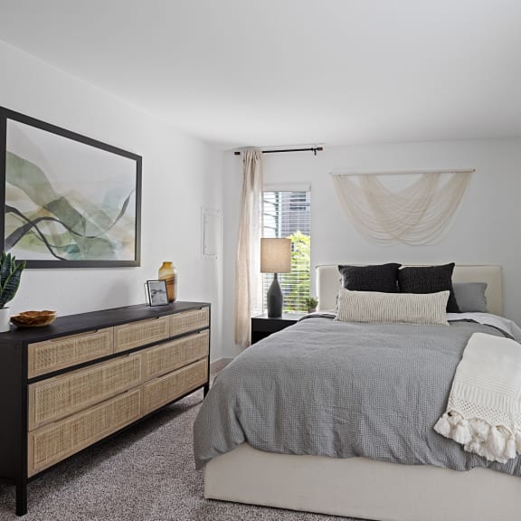 a bedroom with a bed and two windows at The Lakes Apartments, Bellevue Washington