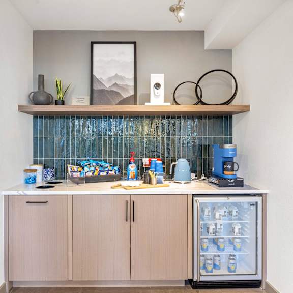 resident coffee station with a blue wall and an elegant white cabinet at 128 on State, Kirkland, WA