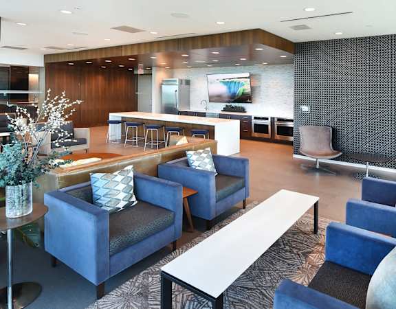 A modern living room with blue chairs and a white coffee table.