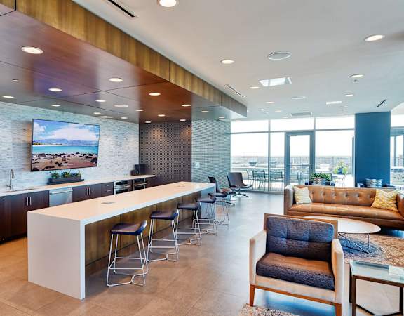 A modern kitchen with a bar and seating area.
