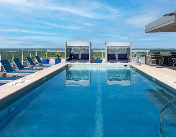 A large outdoor swimming pool with lounge chairs and a view of the horizon.