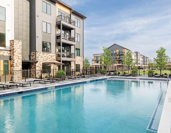 Resort-style swimming pool with ample lounge seating - Stonehill at West Orange