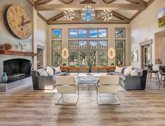 A living room with a fireplace and a large clock on the wall.