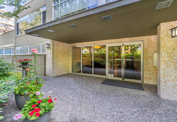 A patio area with a glass door entrance and a potted plant.