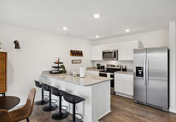 A modern kitchen with a large island and stainless steel appliances at The Summit Townhomes in Oak Ridge, Tennessee 37830