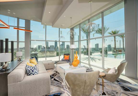a living room with a view of the water and a couch and chairs at Vista Brooklynn Apartments, Jacksonville