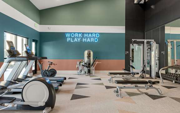 A gym with a variety of equipment including treadmills, stationary bikes, and weight machines. at Bridge at Tech Crossing, Austin, Texas