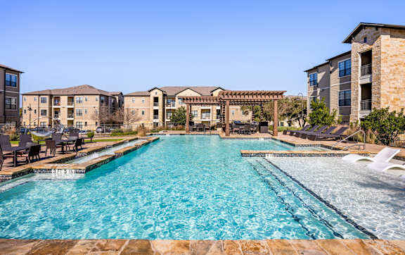A large swimming pool in front of a resort. at The Royce at 8100, Austin