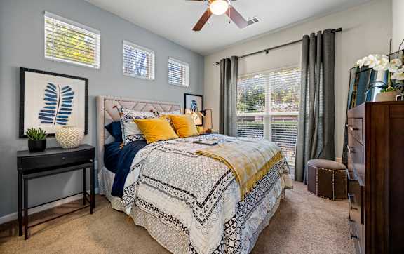 A dining room with a table set for two and a view of a bedroom through the door. at The Royce at 8100, Austin, TX, 78729