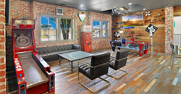 A room with a bowling alley and a pool table.