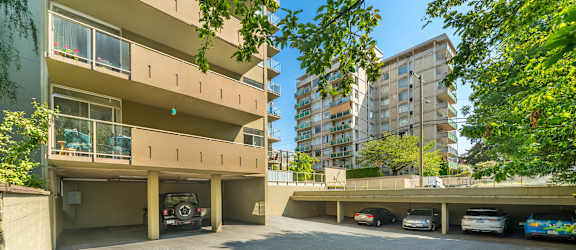A parking lot with cars and a building in the background.