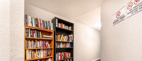 A room with a bookshelf and a no smoking sign.