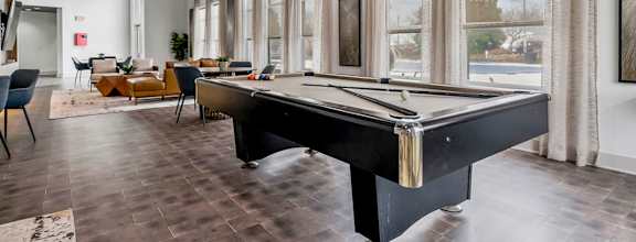 a game room with a pool table and windows at CityView, North Kansas City, MO