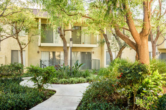 a sidewalk in front of a building with trees and plants at Village Pointe Apartments, Northridge, CA, 91325