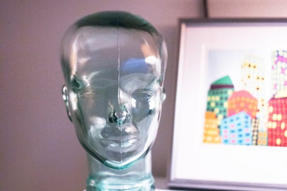 a glass head on a shelf next to a picture