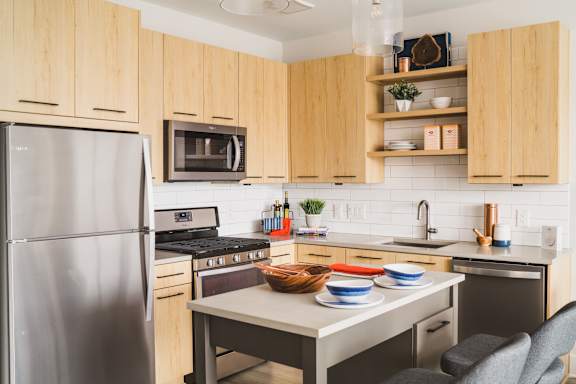 A kitchen with wooden cabinets and a stainless steel refrigerator.