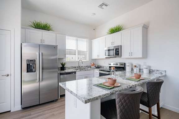 a kitchen with stainless steel appliances and a marble counter top