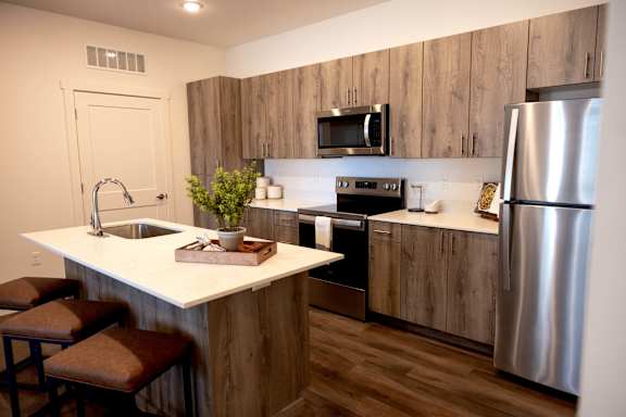 A kitchen with a white counter top and wooden cabinets.