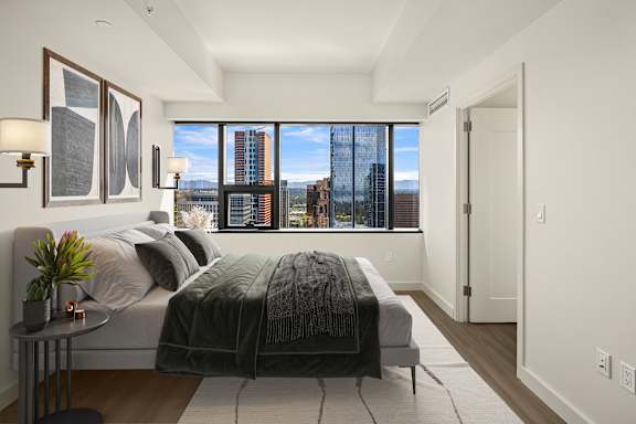 A bedroom with a large bed and a view of the city.