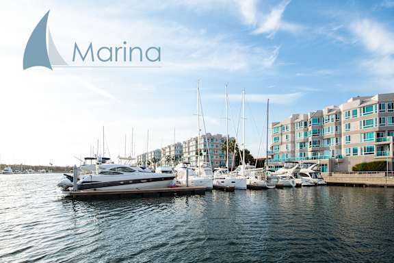 A yacht is docked at a marina with the name "Marina" on the logo.