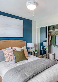 a bedroom with a bed and a blue wall and a closet at The Villas at Ibis Landing, Parkland, Florida