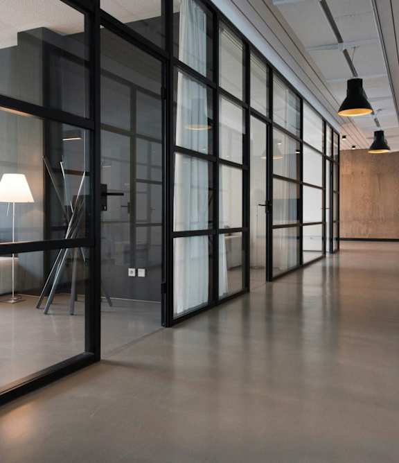 a glass walled room with a couch and a table