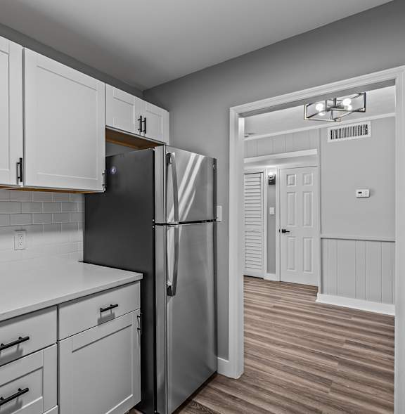 A kitchen with white cabinets and a black fridge. at Serenity Place Central, Tallahassee, FL, 32304