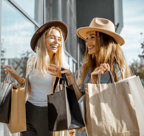 a woman walking through a clothing store with a bag
